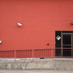 Security camera and rear entrance on a commercial building: Roughly One in Three UK Business Premises Will Suffer Crime This Year