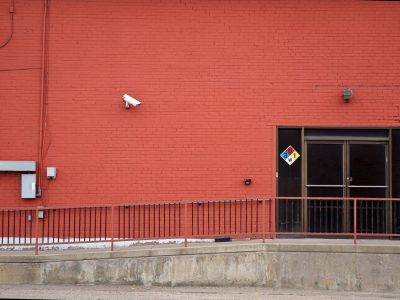 Security camera and rear entrance on a commercial building: Roughly One in Three UK Business Premises Will Suffer Crime This Year