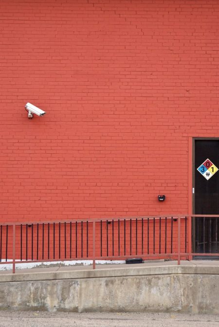 Security camera and rear entrance on a commercial building: Roughly One in Three UK Business Premises Will Suffer Crime This Year