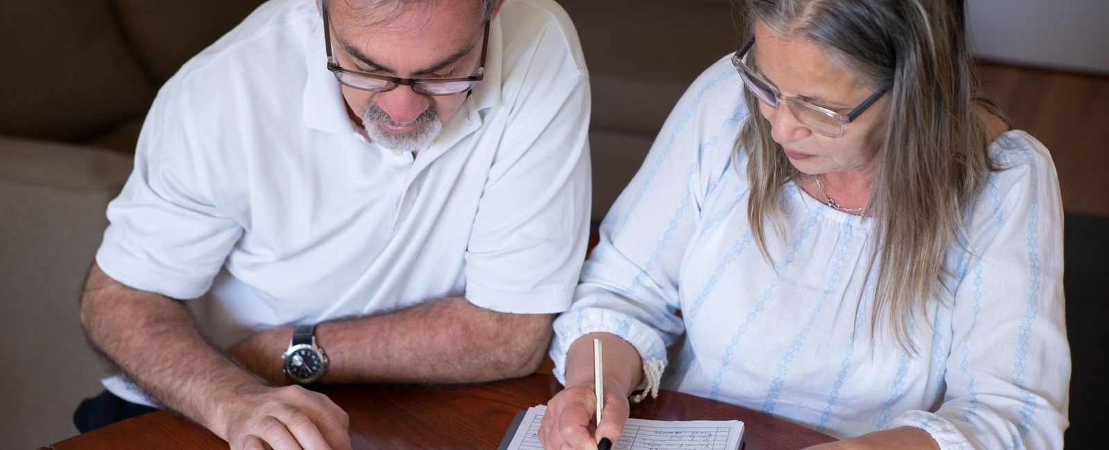 Pension cash taken too soon can create problems you did not expect: an older couple going through pension and retirement paperwork together at home