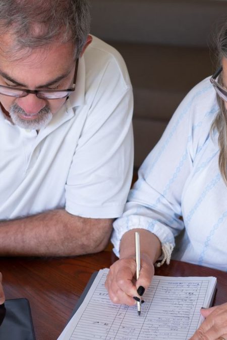 Pension cash taken too soon can create problems you did not expect: an older couple going through pension and retirement paperwork together at home