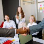 Two colleagues shaking hands in an office