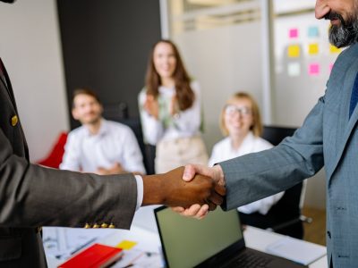 Two colleagues shaking hands in an office